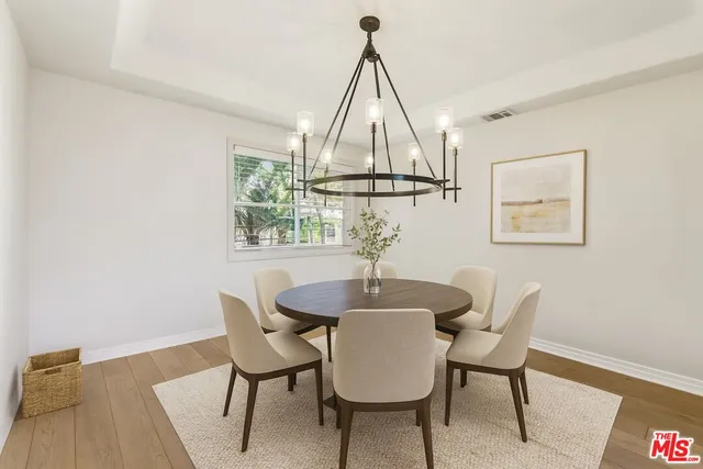 a view of a room with wooden floor fan and windows