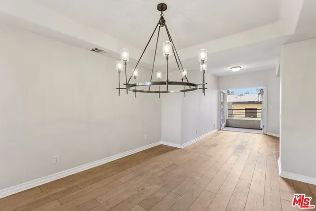 a kitchen with stainless steel appliances a refrigerator sink and wooden floor