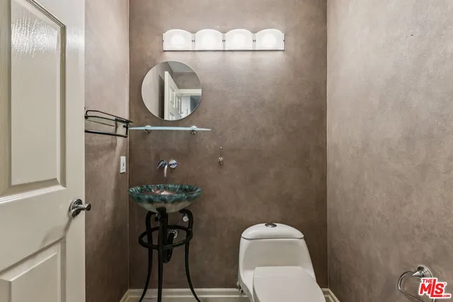 a bedroom with a bed a mirror on dresser and a window