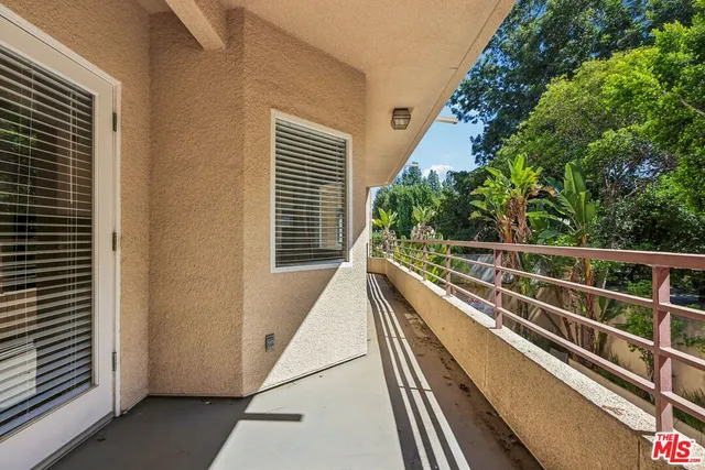 a view of balcony with wooden floor and potted plants