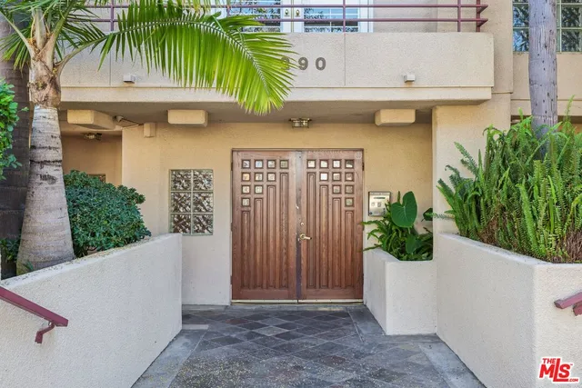 a view of front door with potted plants