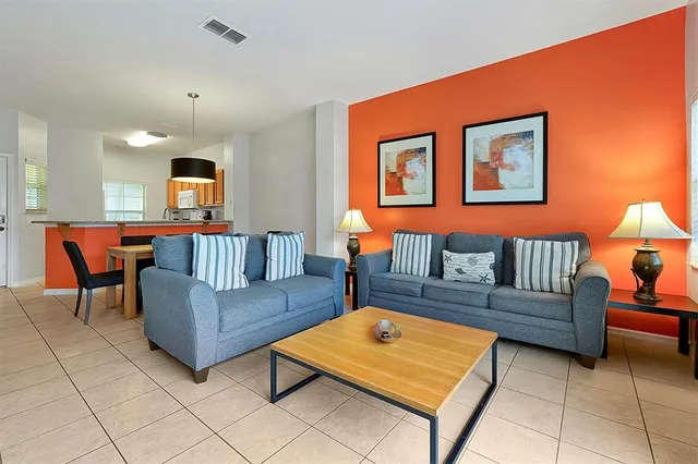 a living room with furniture a rug and a lamp