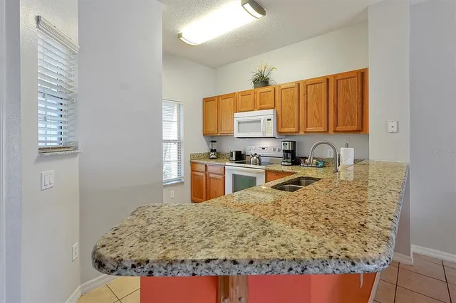 a kitchen with stainless steel appliances granite countertop a stove a sink a microwave and cabinets