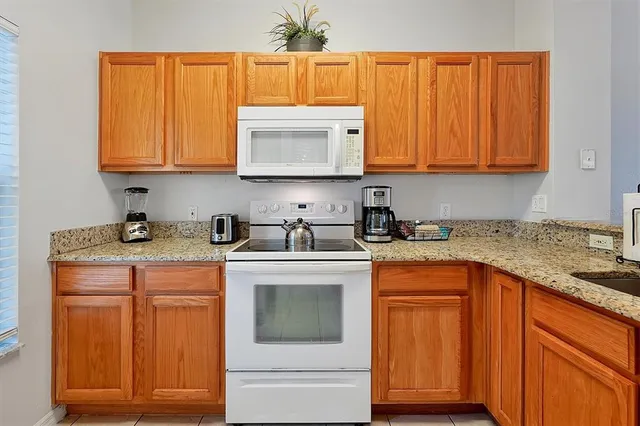 a kitchen with stainless steel appliances granite countertop a sink and a microwave