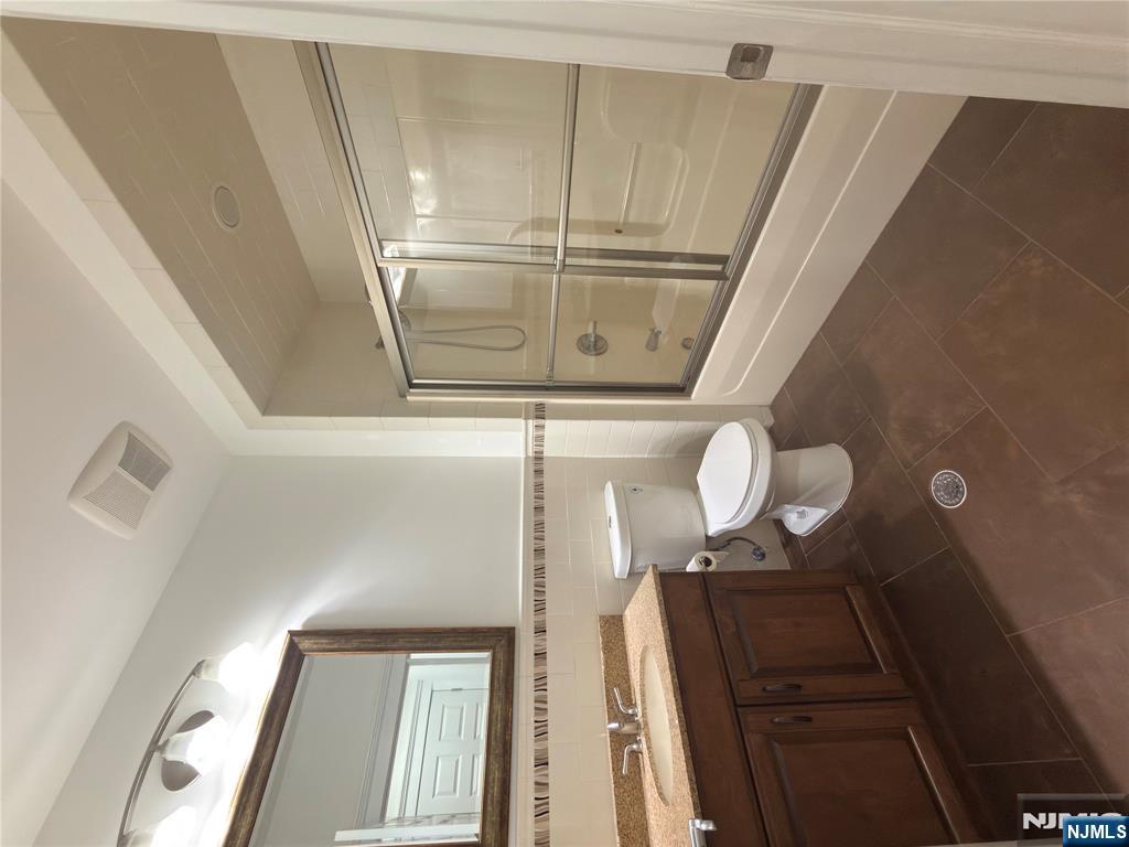 725 River Road, Unit 1B New Milford, NJ 07646 - Photo 5 of 9 a bathroom with a sink a toilet and a mirror