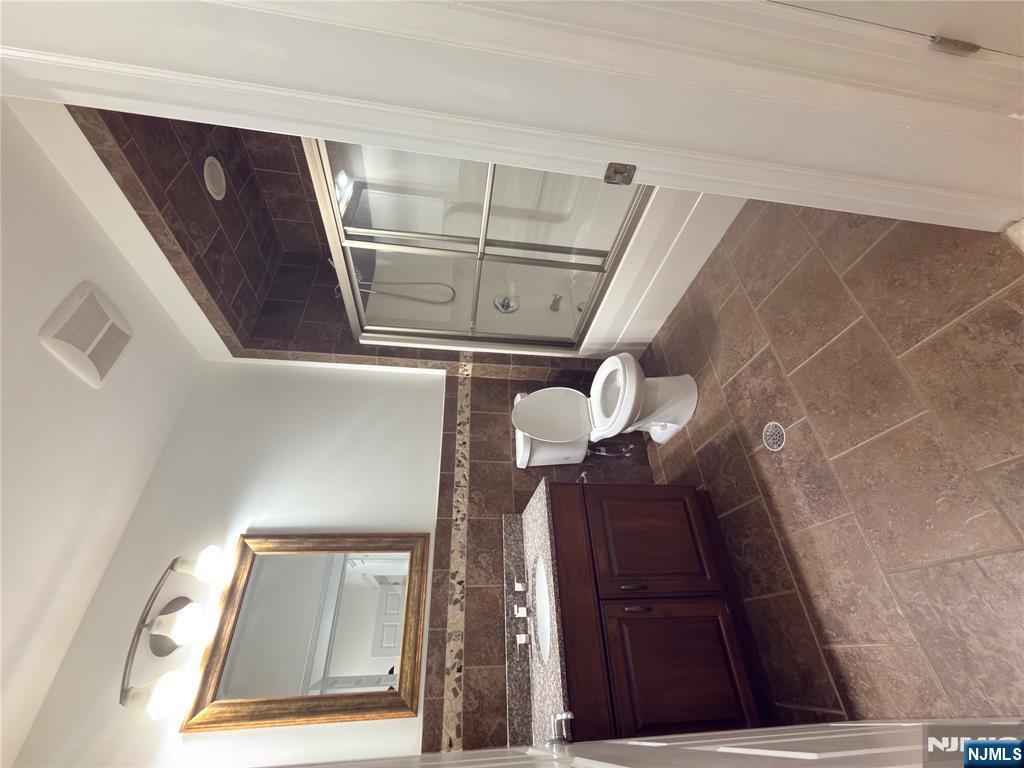 725 River Road, Unit 1B New Milford, NJ 07646 - Photo 9 of 9 a bathroom with a toilet a sink and mirror