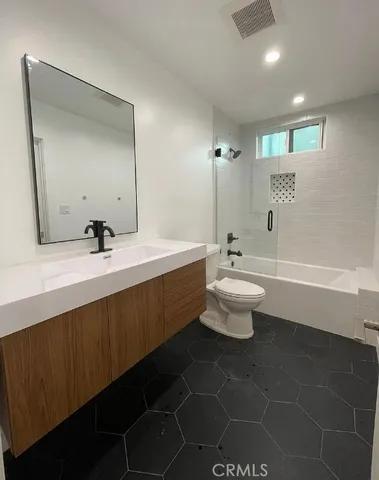 a bathroom with a double vanity sink toilet and a mirror