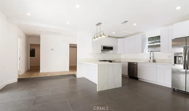 a kitchen with kitchen island a sink stainless steel appliances and cabinets