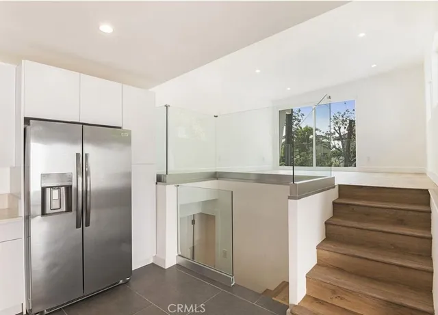 a kitchen with white cabinets and refrigerator