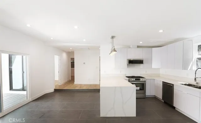 a view of kitchen with sink refrigerator and window