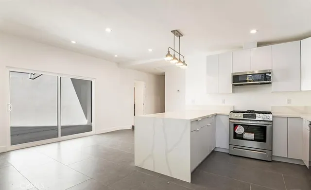 a kitchen with stainless steel appliances granite countertop a stove a sink and a refrigerator