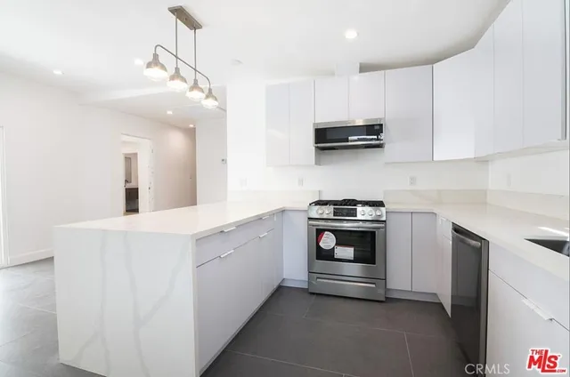 a kitchen with stainless steel appliances a stove sink and cabinets