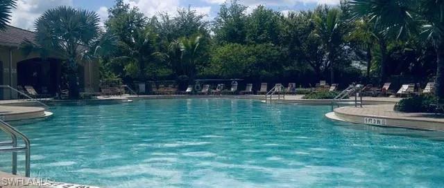 a view of a swimming pool with a bench and trees