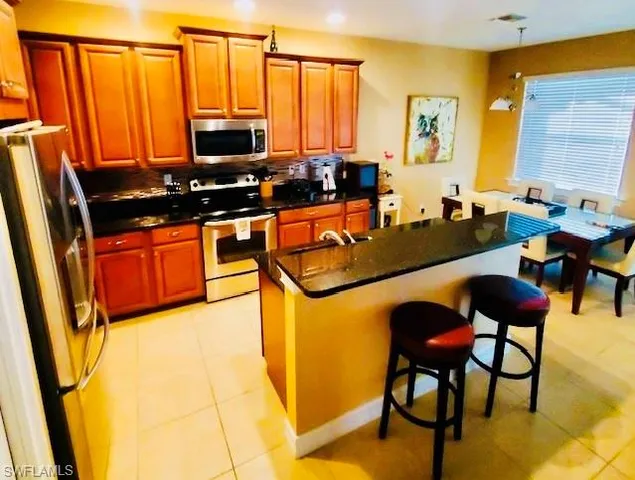 a kitchen with stainless steel appliances granite countertop sink stove and a refrigerator