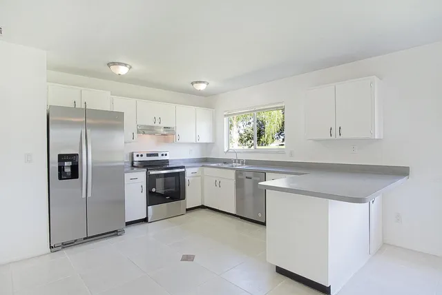 a kitchen with a refrigerator sink and cabinets