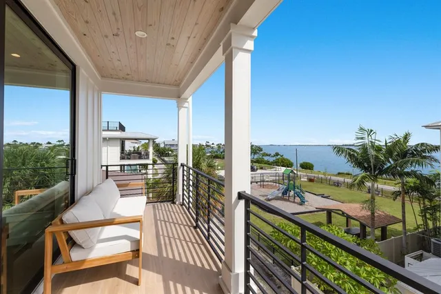 a view of a brick house with a large tree and flower plants