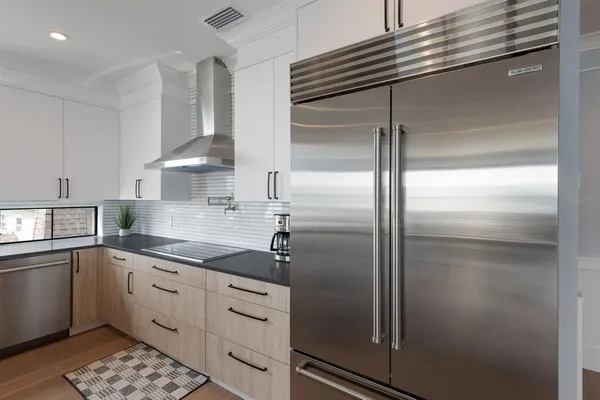 a kitchen with granite countertop a stove a sink and a dishwasher next to a window