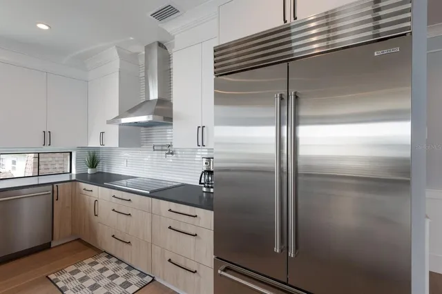 a kitchen with granite countertop a stove a sink and a dishwasher next to a window