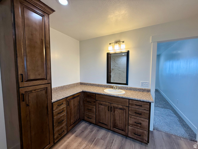 2865 North 3250 W Road Sutherland, UT 84624 - Photo 10 of 28 Spacious vanity featuring an integrated sink, granite-style countertop, and rich wood cabinetry with ample storage