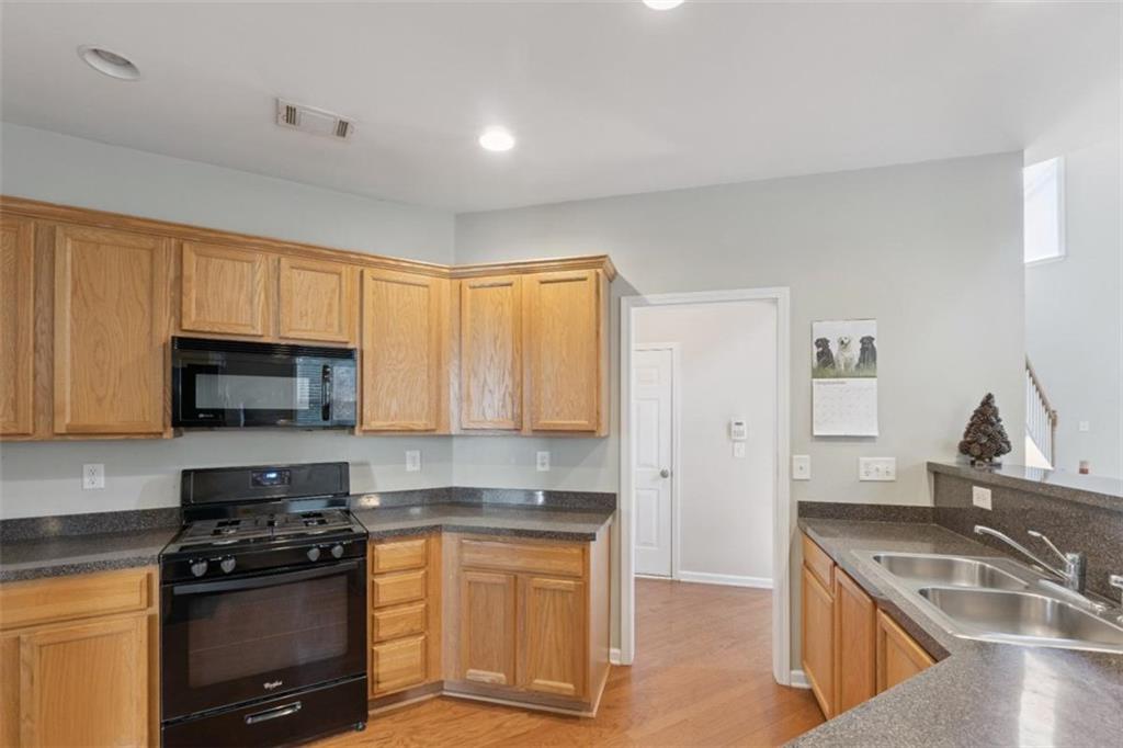 2747 High Creek Run Dacula, GA 30019 - Photo 17 of 48 a kitchen with granite countertop a sink and a stove top oven