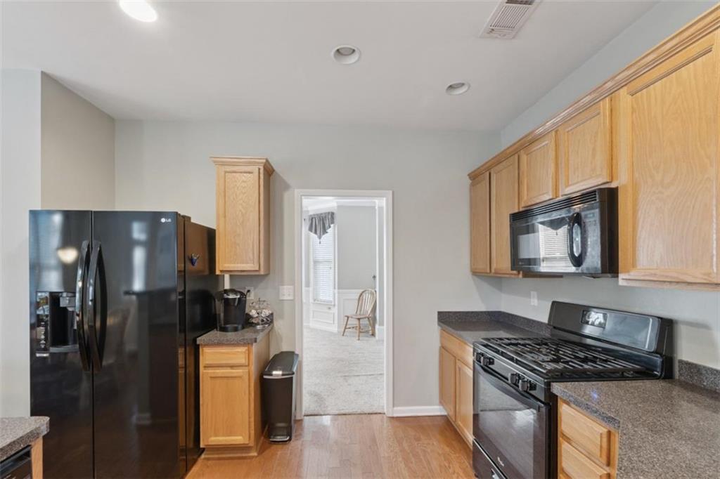 2747 High Creek Run Dacula, GA 30019 - Photo 18 of 48 a kitchen with stainless steel appliances granite countertop a refrigerator stove and sink