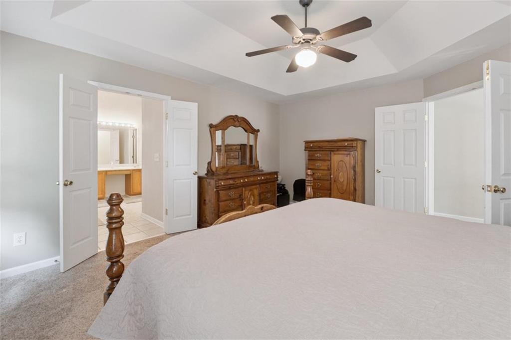 2747 High Creek Run Dacula, GA 30019 - Photo 31 of 48 a bedroom with a bed and a chandelier