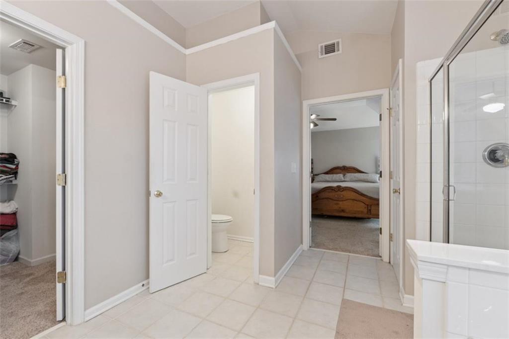 2747 High Creek Run Dacula, GA 30019 - Photo 35 of 48 a bedroom with a bed and a view of en suite bathroom