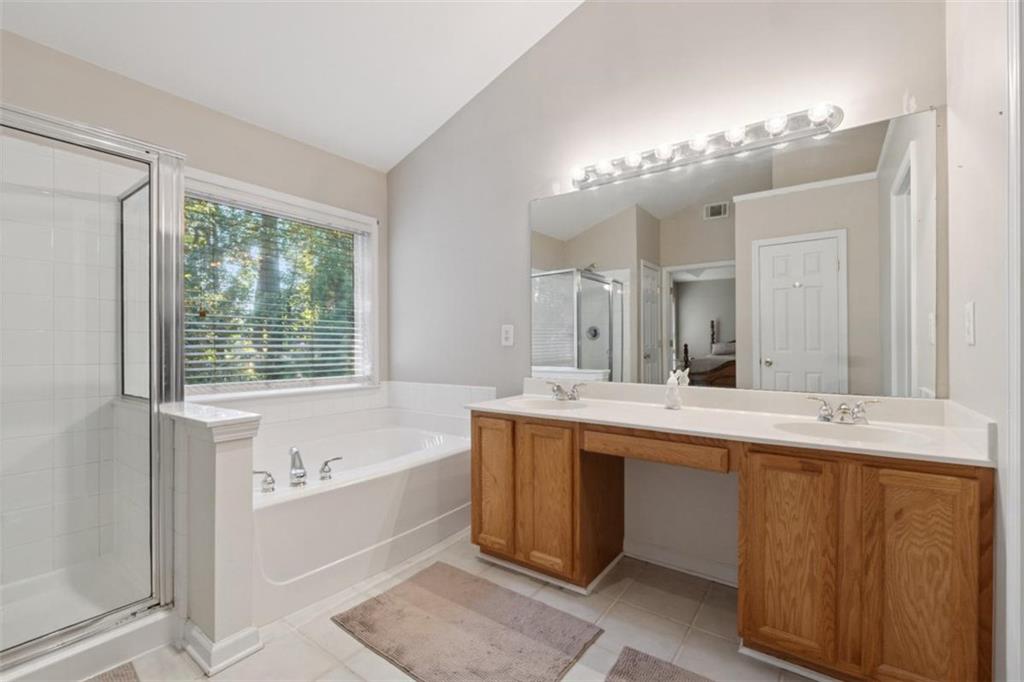 2747 High Creek Run Dacula, GA 30019 - Photo 37 of 48 a large bathroom with a large tub sink and mirror