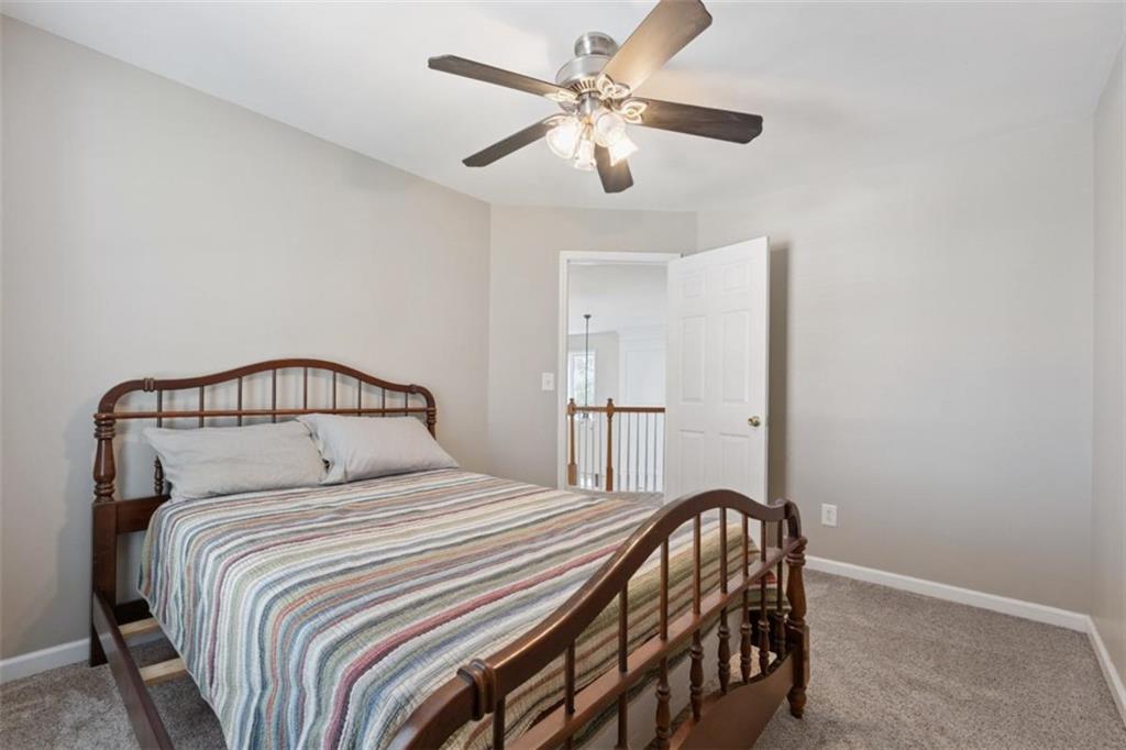 2747 High Creek Run Dacula, GA 30019 - Photo 41 of 48 a bedroom with a bed and a chandelier