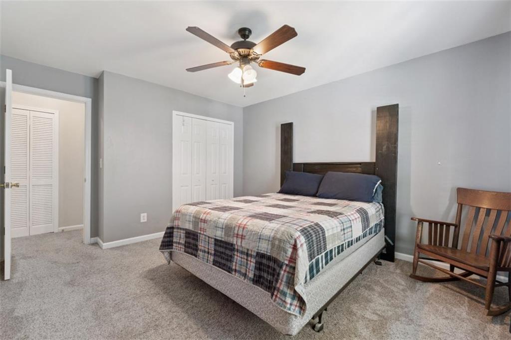 2747 High Creek Run Dacula, GA 30019 - Photo 43 of 48 a bedroom with a bed and a chandelier