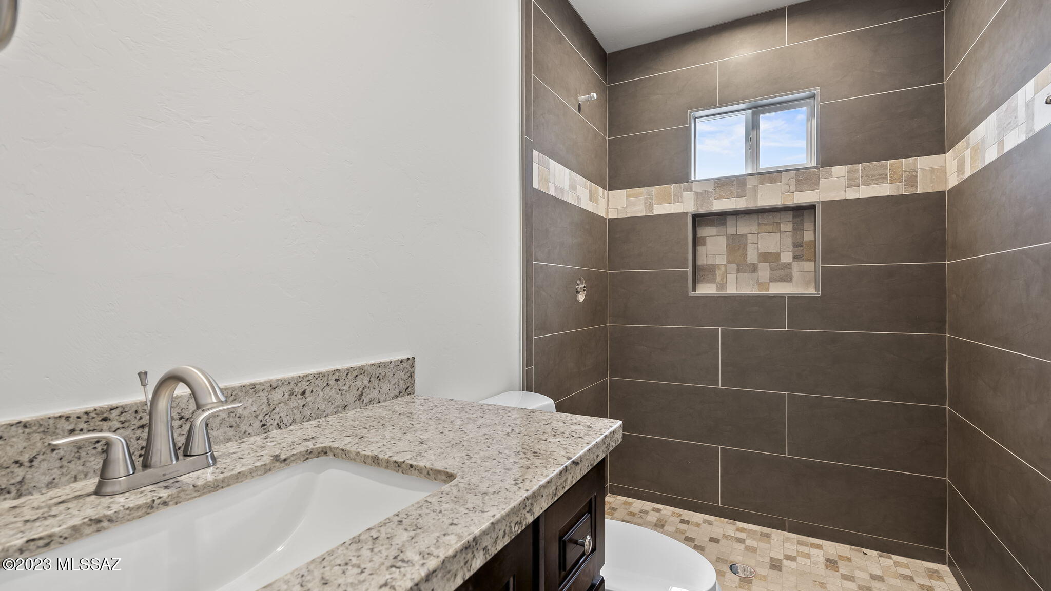 1019 Paseo Guebabi Rio Rico, AZ 85648 - Photo 21 of 25 a bathroom with a granite countertop sink a mirror and shower