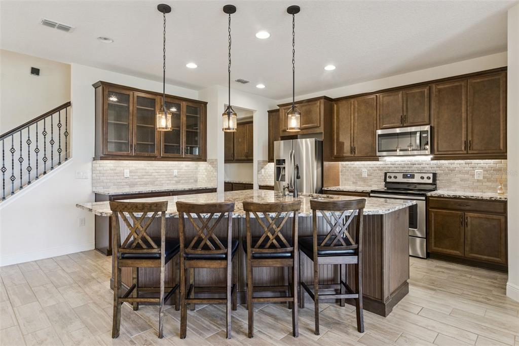 9009 Palm Key Avenue Oldsmar, FL 34677 - Photo 10 of 43 a kitchen with kitchen island granite countertop wooden floor cabinets and appliances