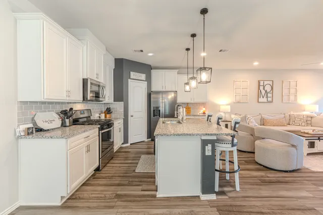 a kitchen with stainless steel appliances granite countertop a sink stove and refrigerator