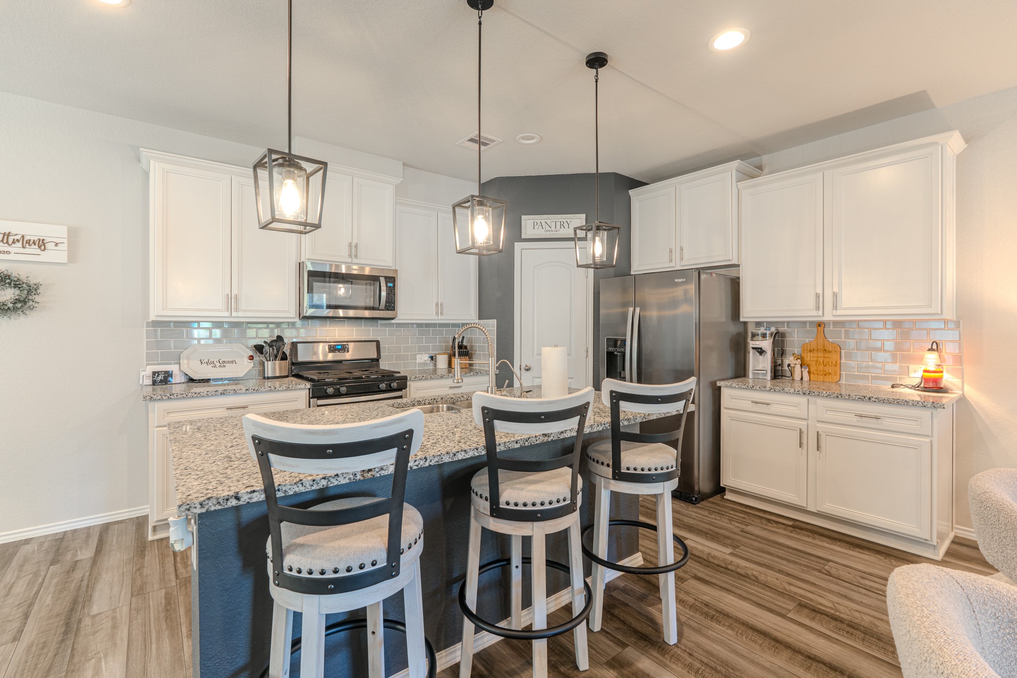 9221 Inland Leather Lane Conroe, TX 77385 - Photo 14 of 47 a kitchen with a dining table chairs refrigerator and microwave