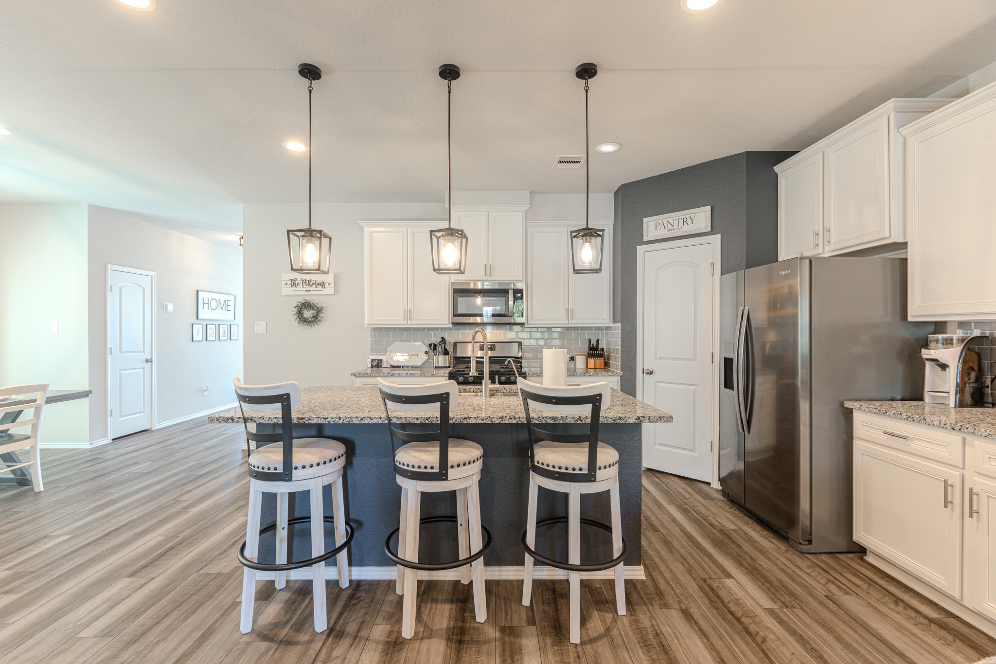 9221 Inland Leather Lane Conroe, TX 77385 - Photo 15 of 47 a kitchen with stainless steel appliances a dining table chairs refrigerator and sink