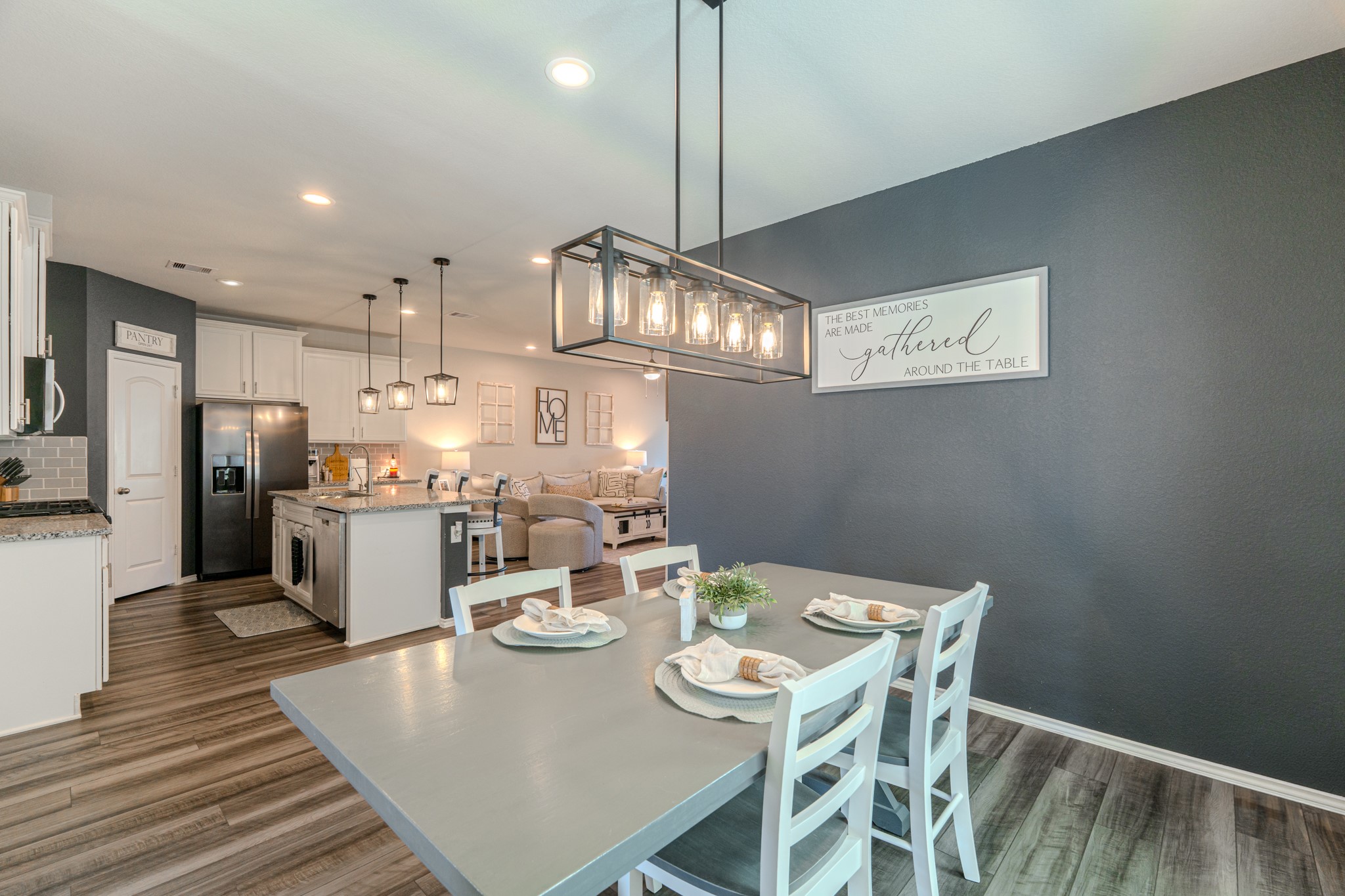 9221 Inland Leather Lane Conroe, TX 77385 - Photo 18 of 47 a dining room with stainless steel appliances kitchen island granite countertop a table chairs and a refrigerator