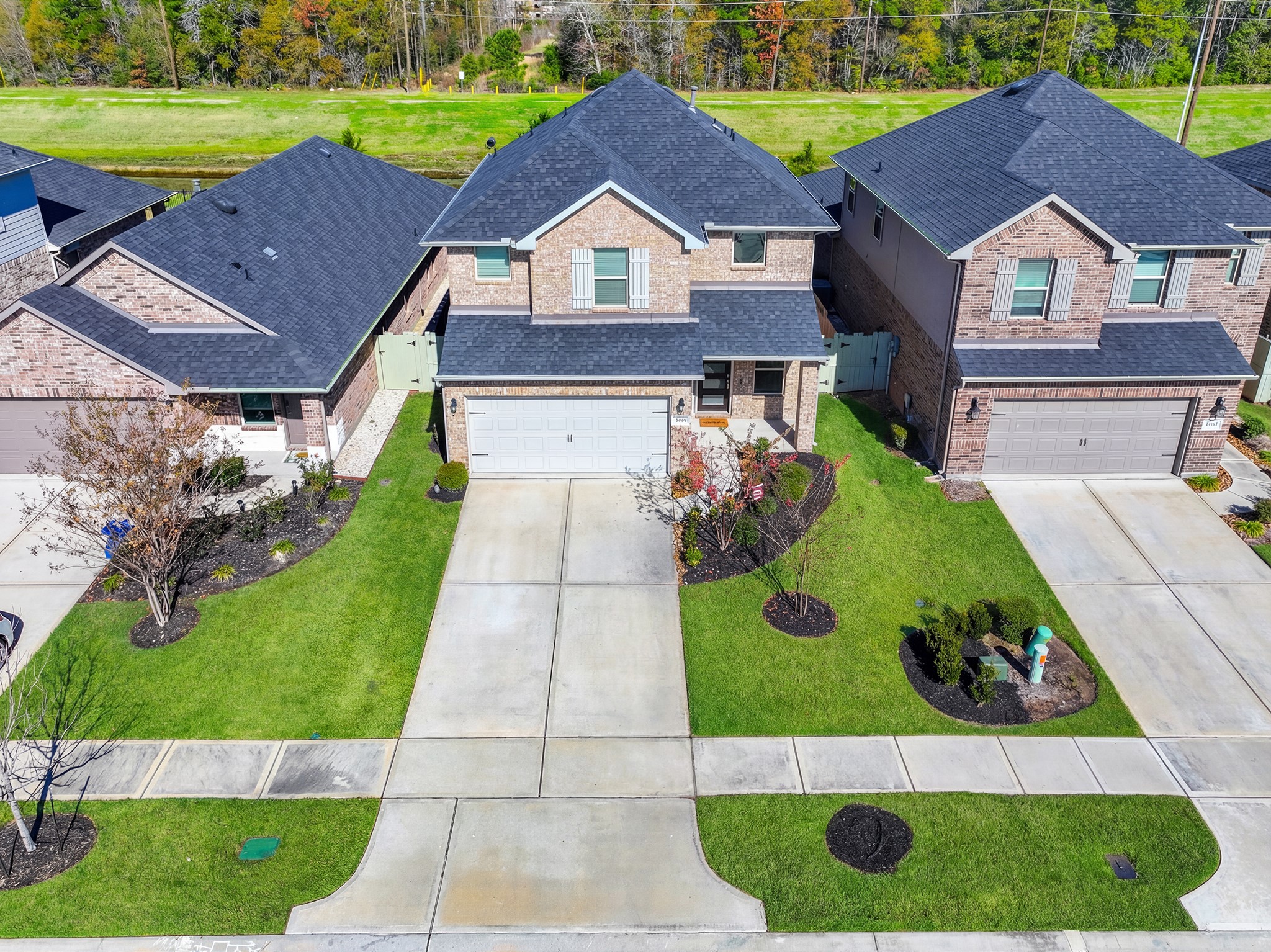 9221 Inland Leather Lane Conroe, TX 77385 - Photo 2 of 47 a aerial view of a house with a yard and potted plants
