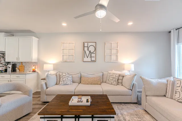 a living room with furniture a rug and a window