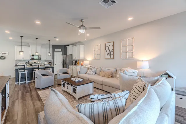 a living room with furniture and kitchen view