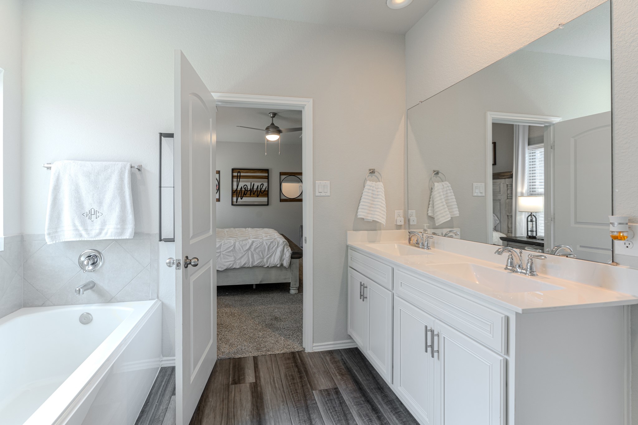9221 Inland Leather Lane Conroe, TX 77385 - Photo 28 of 47 a en suite bathroom with a tub double vanity sink and mirror