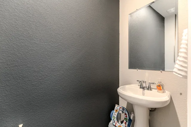 a bathroom with a sink toilet and a mirror