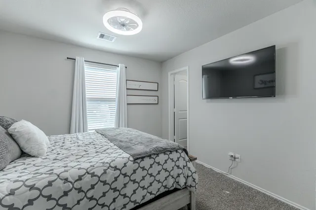 a bedroom with a bed and a flat screen tv
