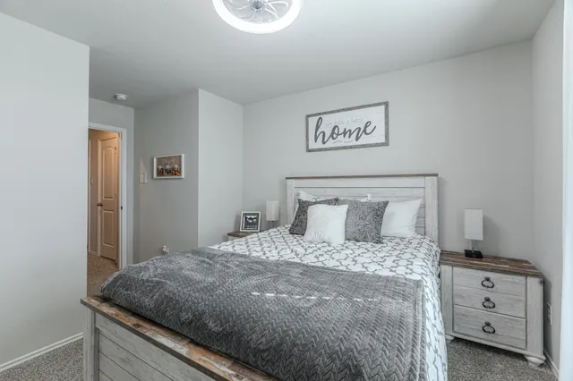 a bedroom with a bed and a night stand