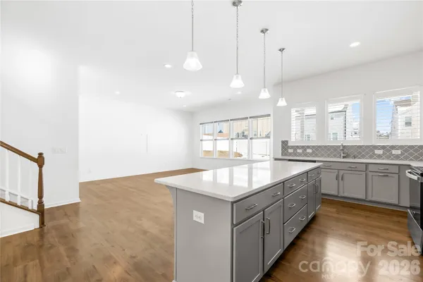 a large kitchen with kitchen island a large counter top a sink and stainless steel appliances