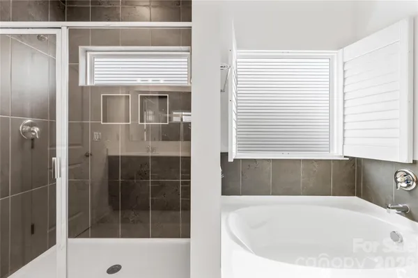 a white bath tub sitting in a bathroom next to a window