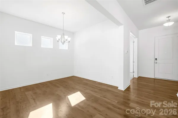 a view of a room with wooden floor and white walls