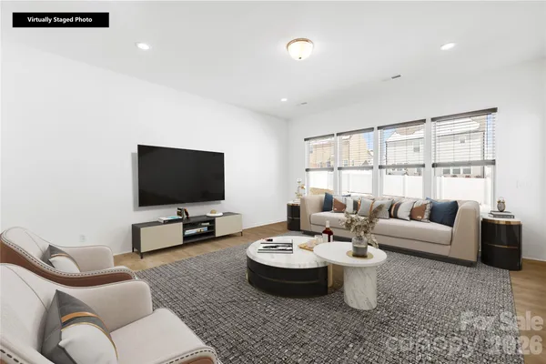 a living room with furniture a flat screen tv and a large window