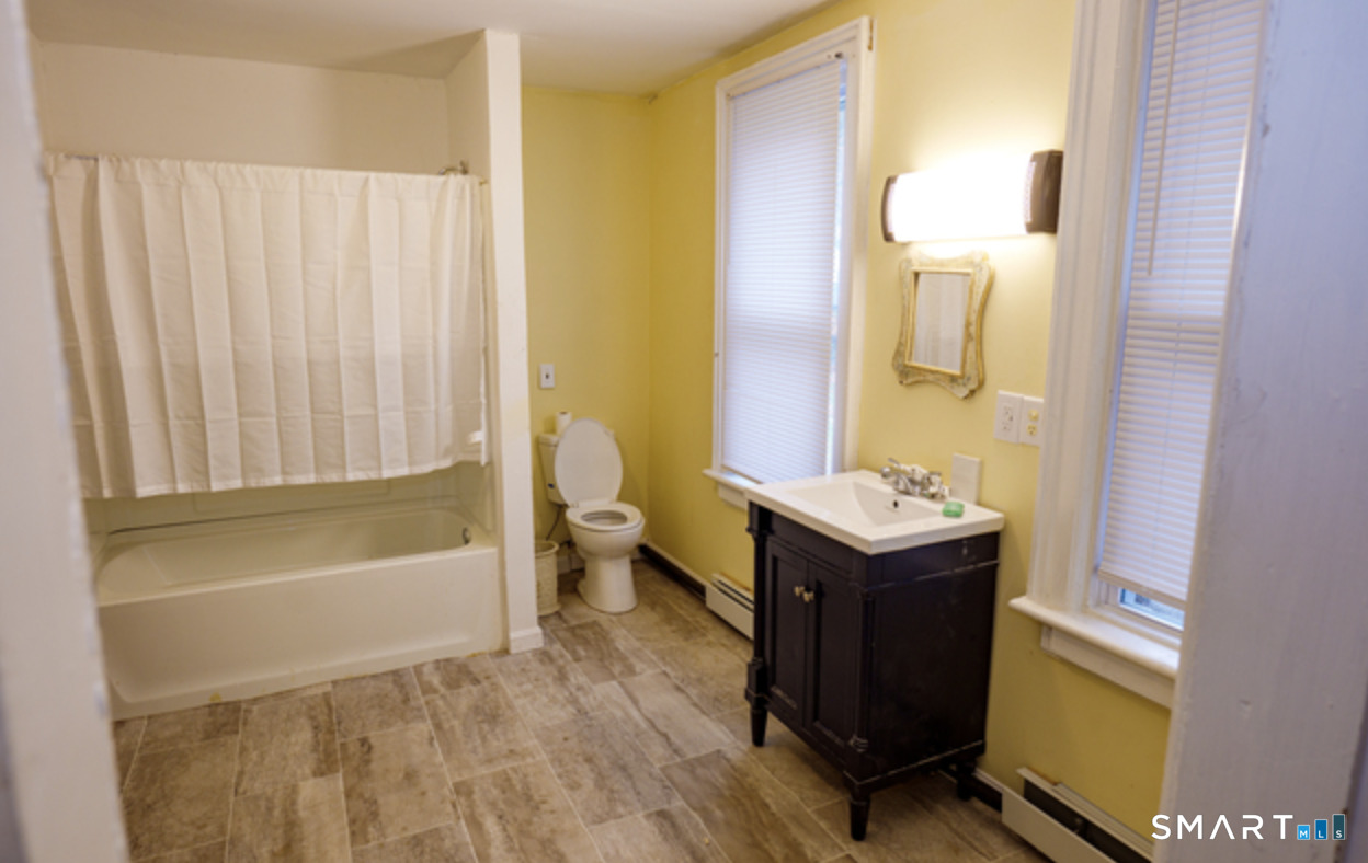30 Main Street Plainfield, CT 06332 - Photo 6 of 14 a bathroom with a sink a toilet and tub