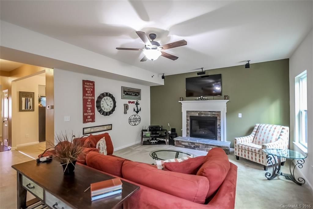 7700 West Berkeley Road Denver, NC 28037 - Photo 2 of 24 a living room with furniture a fireplace and a flat screen tv