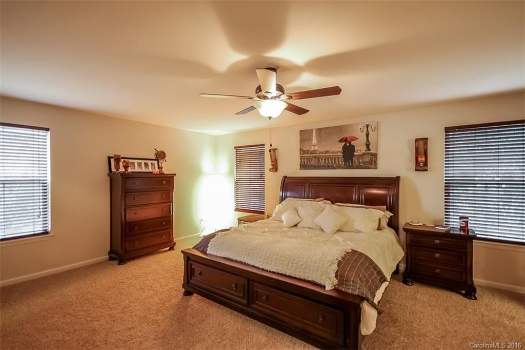 7700 West Berkeley Road Denver, NC 28037 - Photo 12 of 24 a bedroom with a bed and a chandelier